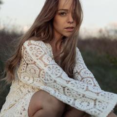 Jeune femme portant une robe Lily Green en dentelle blanche, au charme rétro et à la coupe romantique. Création belge faite main, inspirée des années 50 et du style Jane Austen — handmade Belgian lace dress by Lily Green, pure vintage elegance and timeless femininity / Belgische handgemaakte kanten jurk, romantisch en elegant.