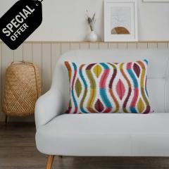 Coussin "Caracas" multicolore sur canapé clair – touche pop et fait main / Kussen "Caracas" in felle kleuren op lichte bank – speelse, handgemaakte toets / Colorful "Caracas" cushion on a light sofa – playful handmade accent