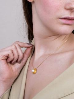 Collier Perla d’Oro porté, éclat doré raffiné pour sublimer vos looks du quotidien. / Perla d’Oro halsketting gedragen, verfijnde gouden glans voor je dagelijkse look. / Perla d’Oro necklace worn, refined golden glow for your daily looks.