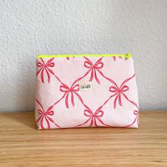 Foto van het artikel Grote driehoekige toilettas – elegant en praktisch met roze strikjes / fluogeel rits