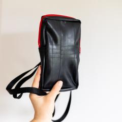 Petit sac bandoulière artisanal Récup’osons en chambres à air de vélo recyclées, design noir avec finition rouge, accessoire mode éco-responsable unique et pratique, parfait comme cadeau durable et original à offrir / Handgemaakt schoudertasje van Récup’osons, gemaakt uit gerecycleerde fietsbinnenbanden, zwart met rode afwerking, ecologisch en uniek modeaccessoire, ideaal als duurzaam geschenk / Récup’osons small crossbody bag handmade from recycled bicycle inner tubes, black with red details, eco-friendly and stylish accessory, perfect sustainable gift idea.