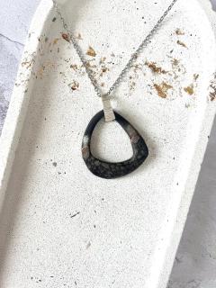 Collier triangle en céramique noire fait main par YuKaï by Kate – design géométrique organique avec finition brute et fondu miel / noir – un bijou rare, symbolique, ancré dans l’art wabi-sabi / Handgemaakt keramisch sieraad in driehoekvorm – YuKaï – Belgisch vakmanschap / YuKaï – handmade black porcelain triangular necklace with gradient tones – minimalist yet expressive