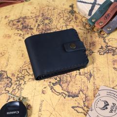 Portefeuille en cuir noir présenté de dessus, lignes épurées et finition artisanale, idée cadeau intemporelle, made in Belgium / Zwarte leren portefeuille van bovenaf gezien, strakke lijnen en ambachtelijke afwerking, tijdloos cadeau-idee, made in Belgium / Black leather wallet top view, clean lines and handcrafted finish, timeless gift idea, made in Belgium