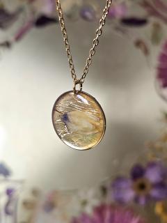 Pendentif lumineux aux reflets dorés et pétale bleu, bijou fait main par Noémie de B&L Atelier, prêt à offrir en écrin / Gouden lichtreflecterende hanger met blauw bloemblad, handgemaakt door Noémie – B&L Atelier, klaar om cadeau te geven / Golden light pendant with blue petal, handmade by Noémie – B&L Atelier, ready to gift in its box