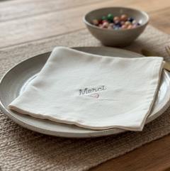 Serviettes de table personnalisées en coton bio crème, présentées sur table, cadeau de maison raffiné et unique, made in Belgium / Gepersonaliseerde tafelserwtten in biologisch katoen crème, gepresenteerd op tafel, verfijnd en uniek huiscadeau, made in Belgium / Personalized organic cotton table napkins in cream, table presentation, refined and unique home gift, made in Belgium
