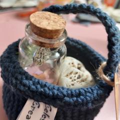 Le Chaudron Magique Sérénité Celestimaje – fiole en verre avec bouchon liège dans écrin textile bleu crocheté main, création artisanale décorative et parfumée fabriquée en Belgique, idée cadeau bien-être originale disponible sur Wimzzi / Magische Ketel Sereniteit Celestimaje – glazen flesje met kurk in handgehaakt blauw textiel mandje, ambachtelijke decoratieve en geparfumeerde creatie uit België verkrijgbaar op Wimzzi / Celestimaje Magical Cauldron Serenity – glass vial with cork in handmade blue crocheted holder, decorative scented Belgian artisan creation available on Wimzzi