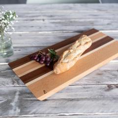 Planche à fromages en bois massif fabrication artisanale belge plateau de service design épuré pour vin charcuterie et apéritif bois noble finition naturelle pièce unique durable disponible sur Wimzzi.com idée cadeau élégante made in Belgium / Houten kaasplank massief hout Belgisch handgemaakt stijlvolle serveerplank voor wijn en tapas duurzaam design verkrijgbaar via Wimzzi.com / Solid wood cheese board handmade in Belgium minimalist serving platter for wine and charcuterie natural finish sustainable artisan piece available on Wimzzi.com