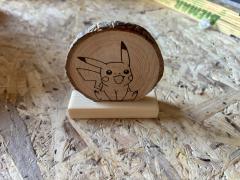 Rondin de bois gravé Pikachu sur socle, décoration artisanale en bois naturel par NEL Nicolas Renard Malmedy, objet déco geek fait main made in Belgium idée cadeau original pour fans Pokémon / Houten schijf op voet met gegraveerde Pikachu decoratie handgemaakt door NEL Nicolas Renard uit Malmedy België, unieke houten decoratie voor Pokémon fans / Wood slice decoration with engraved Pikachu on stand handmade by NEL Nicolas Renard in Malmedy Belgium, unique wooden geek decor gift for Pokémon fans