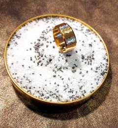 Bague Talos dorée sur support céramique blanc moucheté, contraste fort et chic / Gouden Talos-ring op wit gespikkeld keramiek, opvallend en stijlvol / Gold Talos ring on speckled white ceramic, bold and elegant